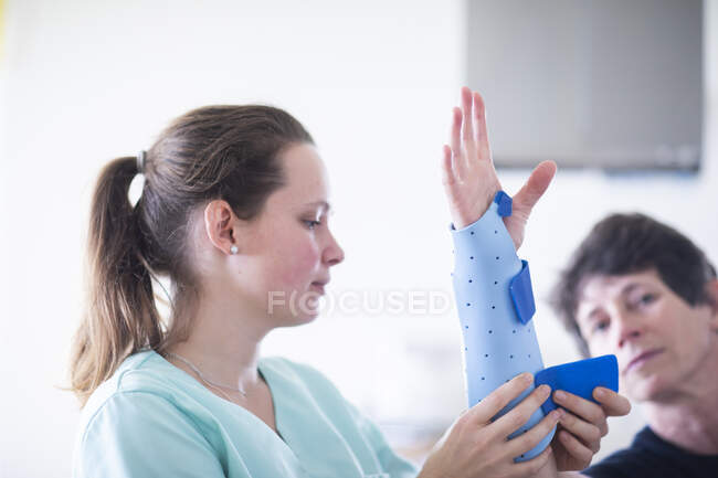 Infirmière tigthing une armbracer à un patient femelle — Photo de stock