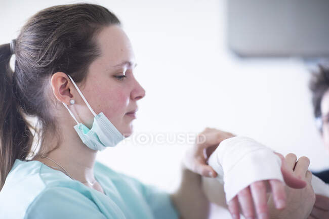 Enfermera haciendo una envoltura a una mujer paciente - foto de stock