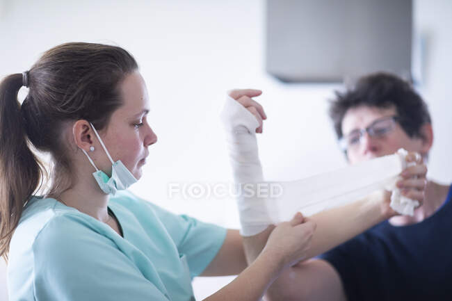 Enfermeira fazendo uma armwraps para uma paciente fêmea — Fotografia de Stock