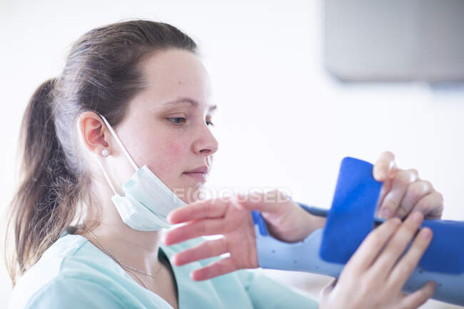 Infermiera tigthing un braccialetto ad una donna paziente — Foto stock