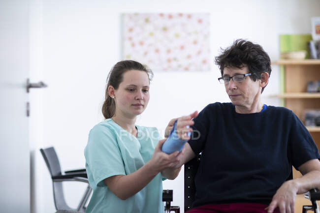 Infermiera tigthing un braccialetto ad una donna paziente — Foto stock