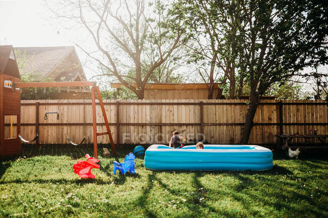 Duas crianças nadando na piscina do quintal — Fotografia de Stock