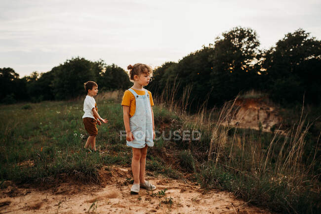 Young brother and sister outside hiking at sunset — Stock Photo