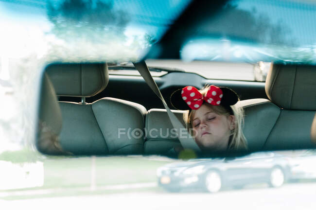 Pequena menina reflexão de retrovisor espelho no carro — Fotografia de Stock