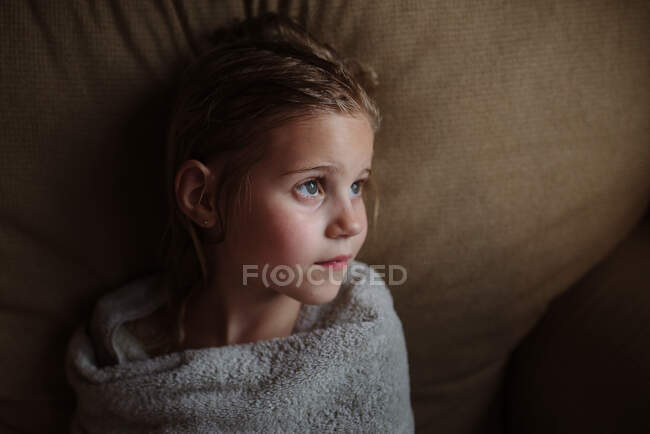 Little girl wrapped in towel after a bath looking away — Stock Photo