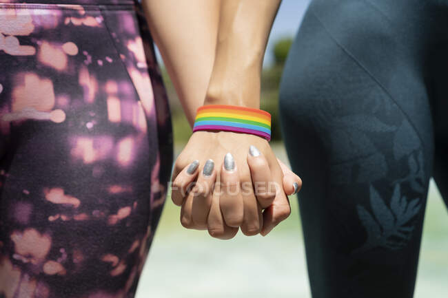 United hands of woman with lgtbi bracelet — стоковое фото