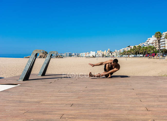 Спортсмен практикует растяжку и гимнастику на улицах своего города — стоковое фото