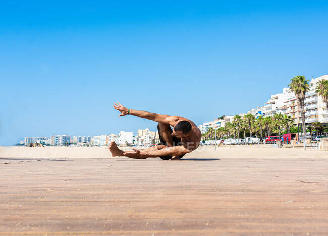 Спортсмен практикует растяжку и гимнастику на улицах своего города — стоковое фото