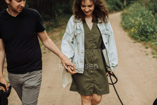 Couple à la première date tenant la main tout en marchant sur le sentier — Photo de stock