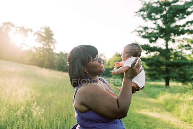 Una madre feliz dando la bienvenida a su hijo recién nacido - foto de stock