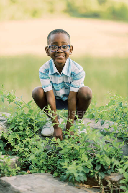 Sweet little boy playing outdoors  in vines — Stock Photo
