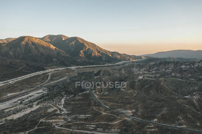 Aerial view over California Country Site Desert Mountains with Highway and Car traffic HQ — Stock Photo