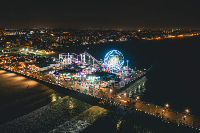 Близько листопада 2019: Santa Monica Pier at Night in supercolourful lights from Aerial Drone perspective in Los Angeles, California HQ — стокове фото