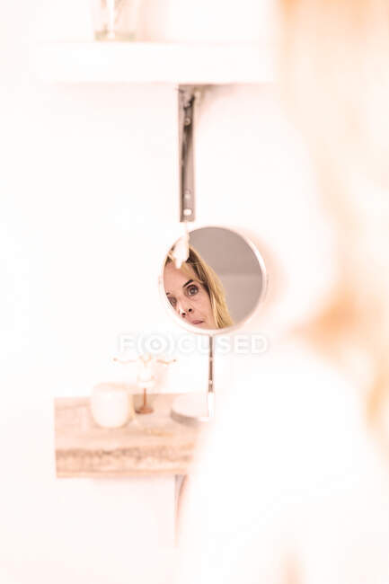 Donna guardando in uno specchio toeletta — Foto stock