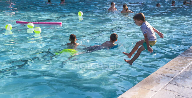 Niños jugando en una piscina . - foto de stock