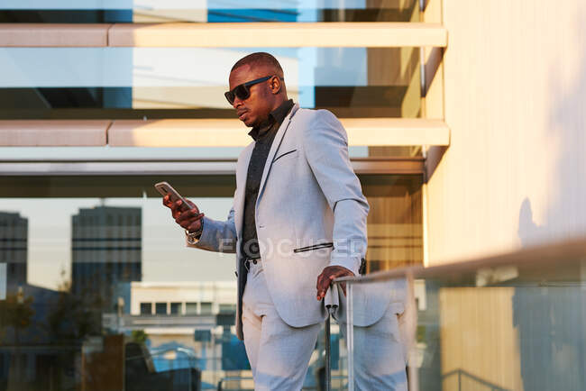 Homme d'affaires afro-américain avec téléphone portable un après-midi d'été. — Photo de stock