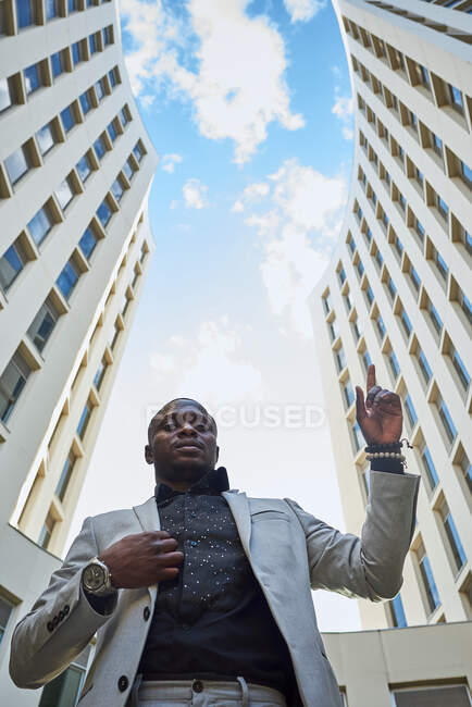 Afroamerikanischer Geschäftsmann zwischen Gebäuden. Er ist ein Leistungsträger. — Stockfoto