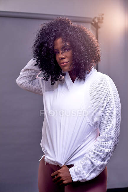 Young woman in athleisure clothing in studio on a grey background — Stock Photo