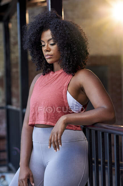 Young woman in athleisure clothing outside brick building — Stock Photo