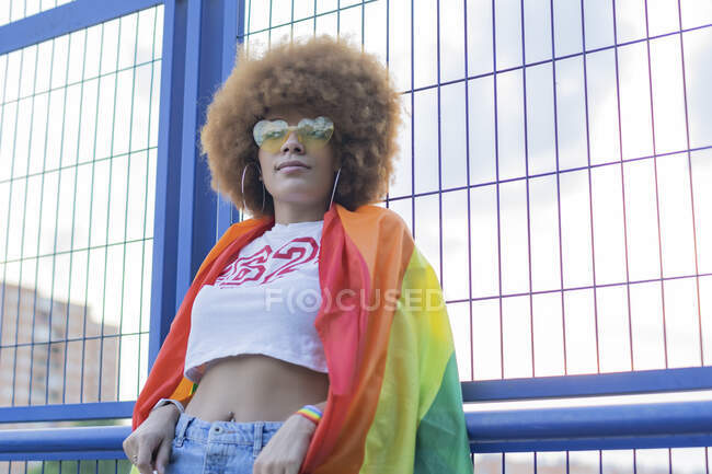 Femme avec afro cheveux avec son gay pride drapeau sur ses épaules — Photo de stock