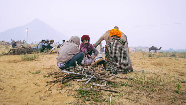 Nómadas sentados junto a un fuego en Pushkar, Rajastán, India - foto de stock