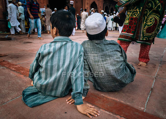 Two kids observing the crowd at Jama Masjid, Delhi, India — Stock Photo