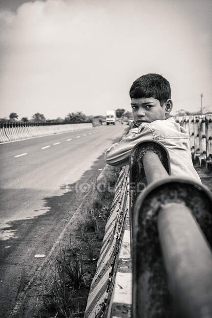 Retrato de uma criança de pé ao lado de uma estrada — Fotografia de Stock