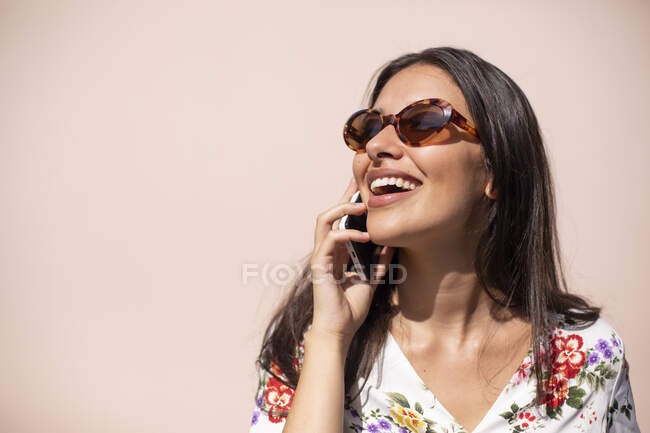 Молода виконавча жінка розмовляє по телефону з рожевим фоном — стокове фото