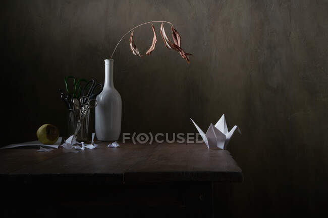 Paper crane and forced emigration. Still life. — Stock Photo