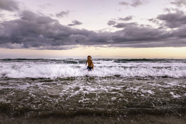 Счастливый пятилетний ребенок, бегущий в море — стоковое фото