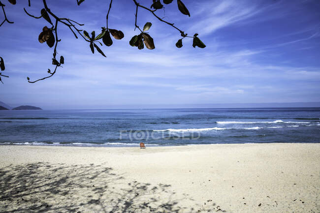 Cadeira de praia vazia de frente para o oceano na praia em um dia ensolarado — Fotografia de Stock