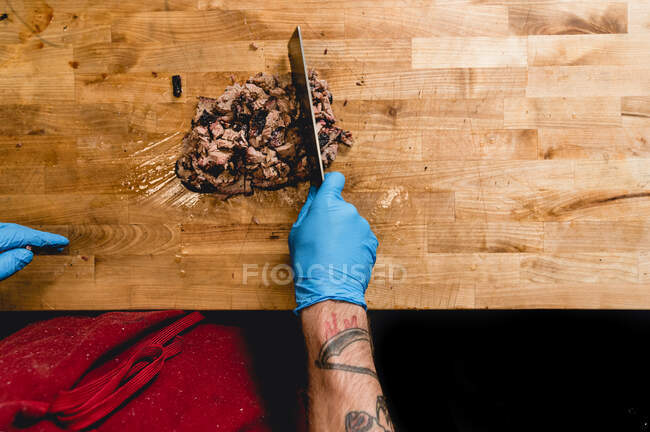 Man Chopping Brisket at a Texas Barbecue Restaurant — стокове фото
