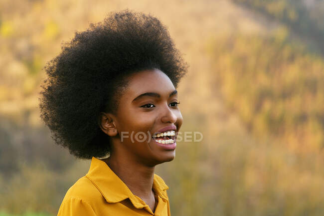 Mujer afroamericana sonriendo feliz en la naturaleza - foto de stock