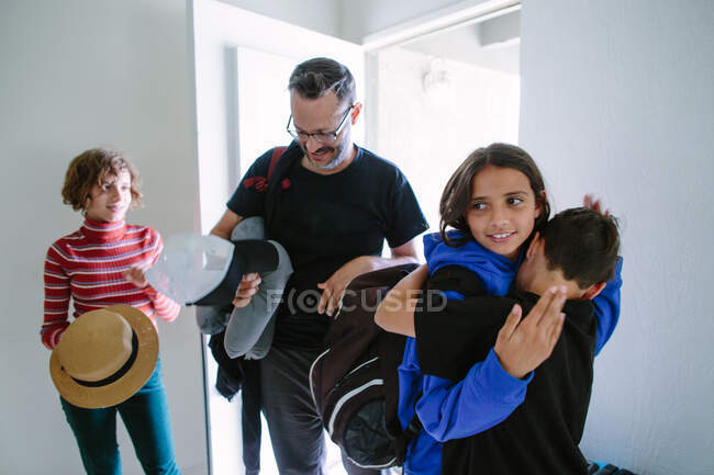 Девушка получает объятия от своего брата после возвращения домой из поездки — стоковое фото