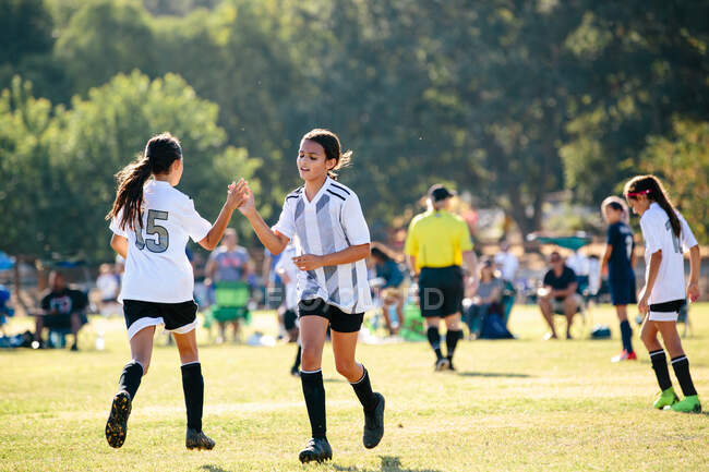 Jogador de futebol menina dá a seu companheiro de equipe um alto cinco — Fotografia de Stock
