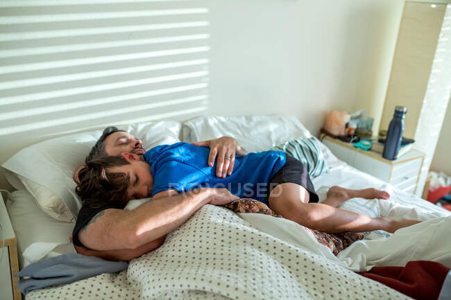 Ragazzo abbracci padre mentre giacevano a letto cattura un po 'più chiuso occhio — Foto stock