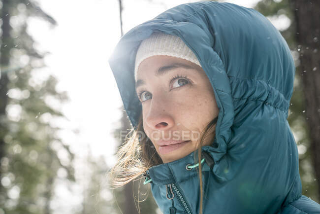 Woman glances up as snow falls around her in Lake Tahoe, CA — Stock Photo