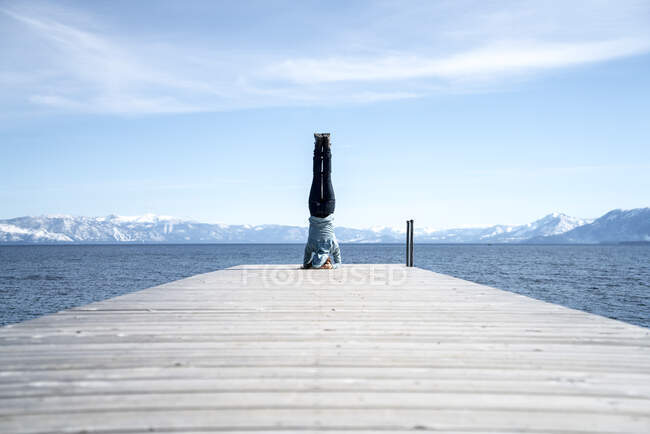 Femme fait un appui-tête au bout d'une jetée à South Lake Tahoe, CA — Photo de stock
