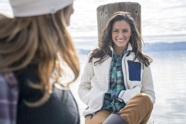 Lächelnde Frau hängt mit ihrem Freund an Pier — Stockfoto