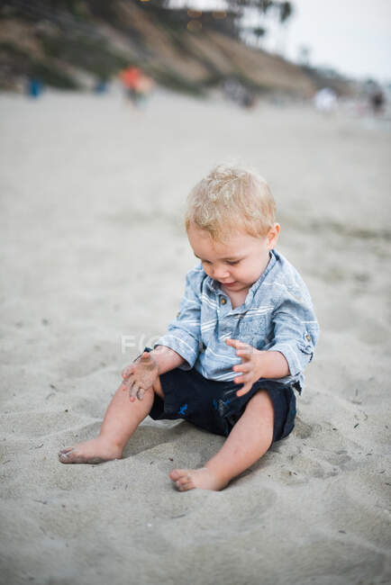 Menino brincando com areia em uma praia da Califórnia — Fotografia de Stock