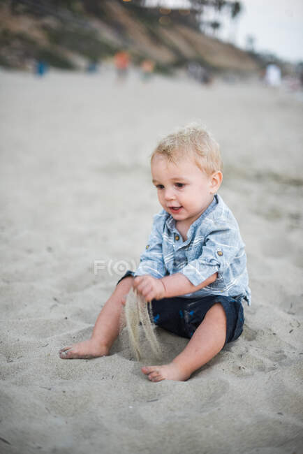 Мальчик играет с песком на пляже Калифорнии — стоковое фото