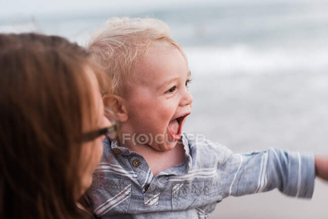 Una madre e suo figlio di un anno che hanno un momento felice in spiaggia — Foto stock