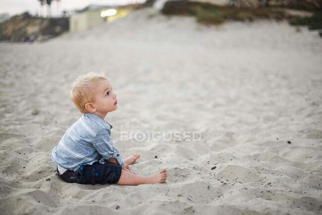 Маленький хлопчик грає з піском на пляжі Каліфорнії. — стокове фото
