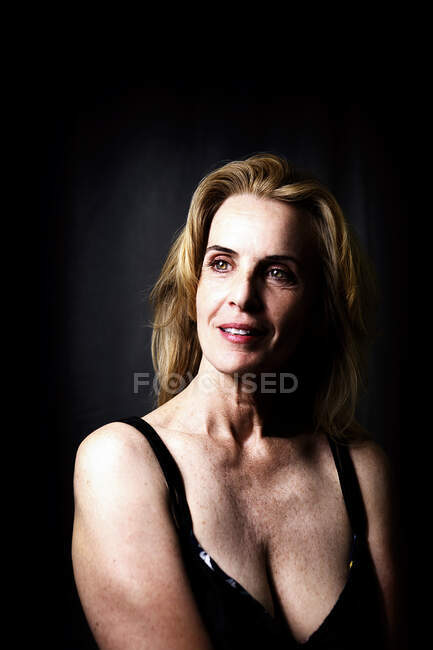 Retrato de una hermosa mujer madura sobre fondo oscuro - foto de stock