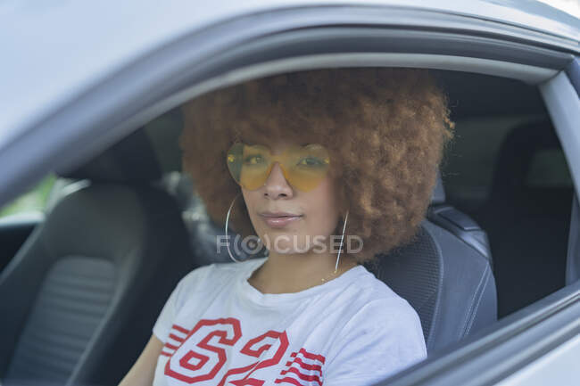 Femme avec des cheveux afro assis dans sa voiture — Photo de stock
