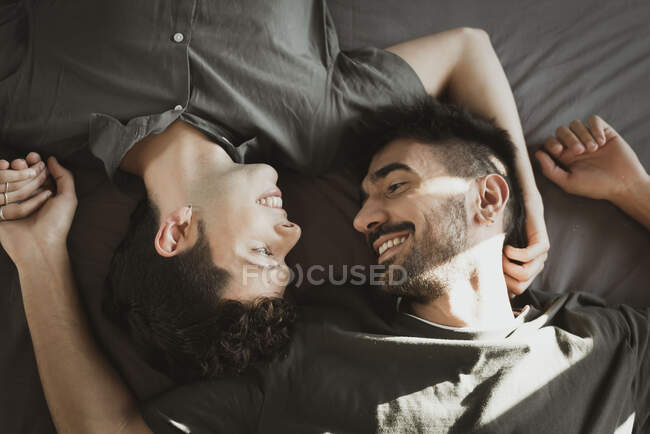 Gay boy couple lying on bed  in the room — Stock Photo