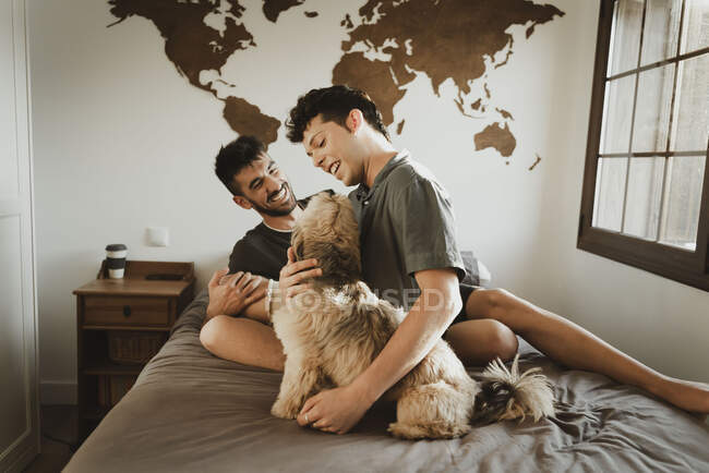 Gay ragazzo coppia con cane in il stanza — Foto stock