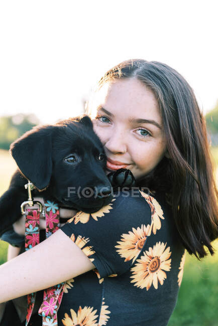 Bella ragazza con simpatico cucciolo labrador all'aperto — Foto stock