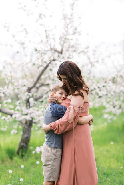 Une mère avec son fils dans un verger de pommiers en fleurs en Nouvelle-Angleterre — Photo de stock
