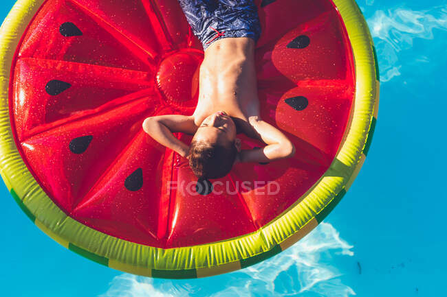 Junge chillt im Pool auf Wassermelonen-Schwimmer — Stockfoto